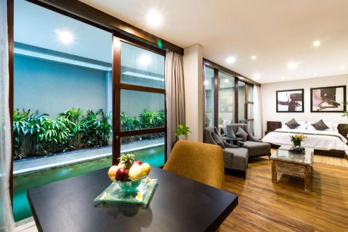 a hotel room with a bed and a large window at Aleesha Villas and Suites in Sanur