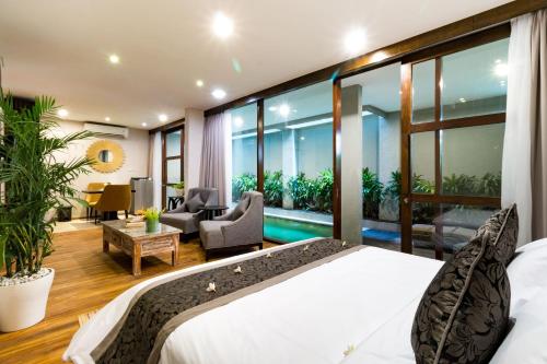a bedroom with a bed and a living room at Aleesha Villas and Suites in Sanur