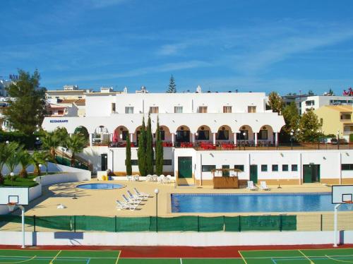 ein großes weißes Gebäude mit einem Pool davor in der Unterkunft Rialgarve in Faro