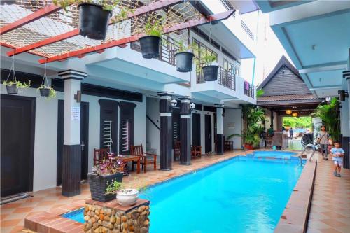 a swimming pool in the courtyard of a building at VIBOLA Guesthouse in Kampot