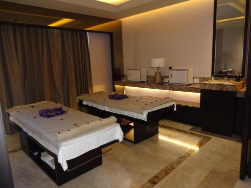 a hotel room with two beds and a mirror at Radisson Blu Coimbatore in Coimbatore