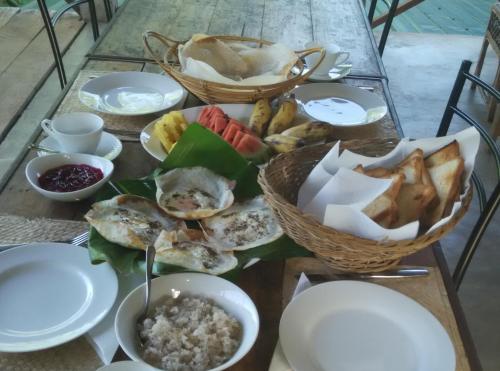 a table topped with plates and bowls of food at Sigiri Forest View in Sigiriya