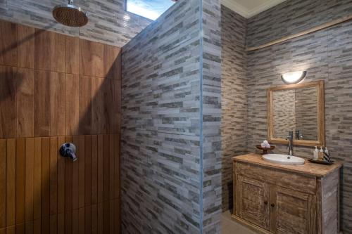 a bathroom with a sink and a mirror at Puri Astina Villa in Ubud
