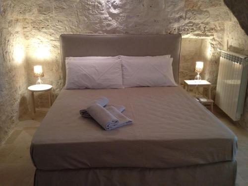 a bed with a towel on it with two lamps at Il Granello Di Senape In Valle D'Itria in Locorotondo
