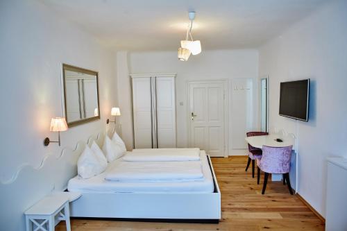 a bedroom with a bed and a desk and a table at Madar Café Restaurant zum Fürsten in Melk