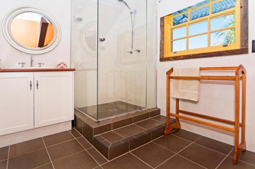 a bathroom with a shower and a sink at Possum Lodge At Cloudhill Estate in Mount Tamborine