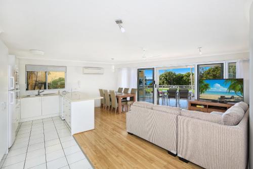 a kitchen and living room with a couch and a table at Belvedere Apartments in Caloundra