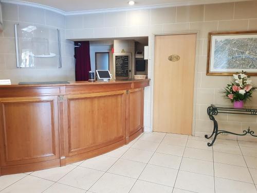 a waiting room with a counter and a kitchen at Hotel Champerret Elysees in Paris
