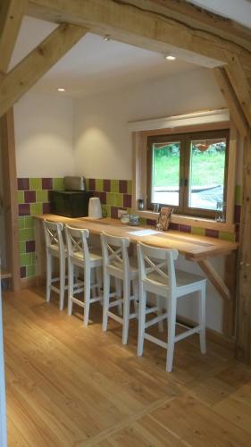une cuisine avec une grande table et des chaises en bois dans l'établissement WillowTree Cottage, à Avèze