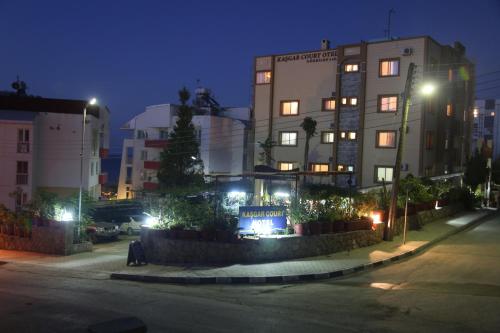 a building with a sign in front of it at night at Kasgar Court Hotel in Karaoğlanoğlu