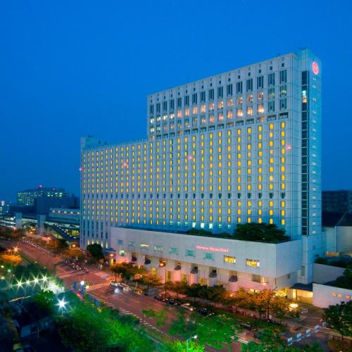a large building with lights on in a city at night at Sheraton Miyako Hotel Osaka in Osaka