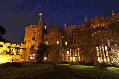 an old castle with a flag on top at night at Thornbury Castle - A Relais & Chateaux Hotel in Thornbury