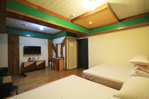 a hotel room with two beds and a flat screen tv at Gemlu in Lugu
