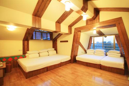 two beds in a room with wooden beams at Gemlu in Lugu