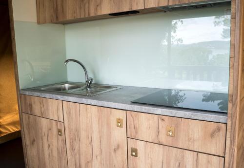 eine Küchentheke mit einem Waschbecken und einem Fenster in der Unterkunft Anfasteröd Gårdsvik - Tälten in Ljungskile