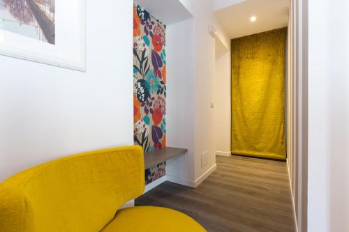a yellow chair in a hallway with a yellow curtain at Ai Suma Hotel in Milan
