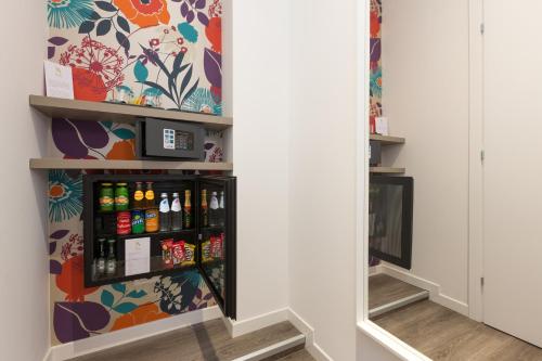 a shelf in a room with alcohol bottles at Ai Suma Hotel in Milan