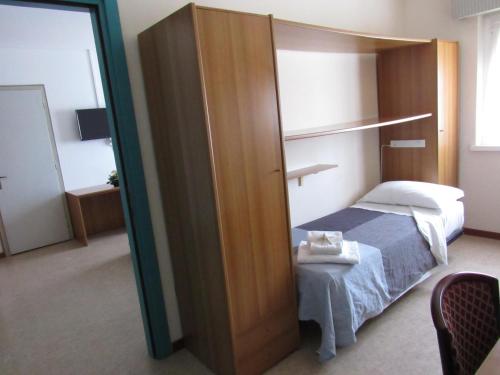 a bedroom with a bed and a large wooden door at Hotel Stella Maris in Grado