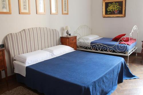 a bedroom with a bed and a chair with a blue blanket at B&B Del Piazzo in Biella