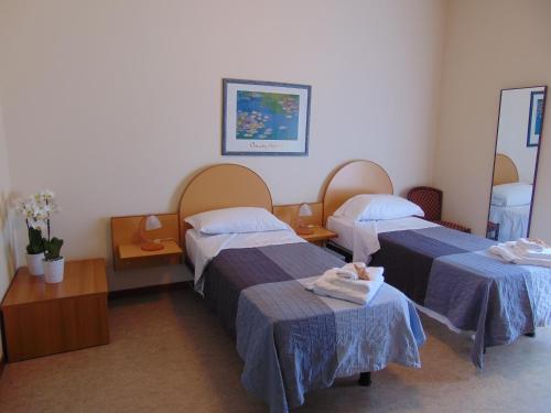 two beds in a hospital room with towels on them at Hotel Stella Maris in Grado