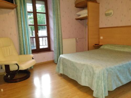 ein Schlafzimmer mit einem Bett, einem Stuhl und einem Fenster in der Unterkunft Hotel Lou Cantou in Chanac