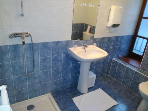 bagno con lavandino e doccia di Hotel Lou Cantou a Chanac