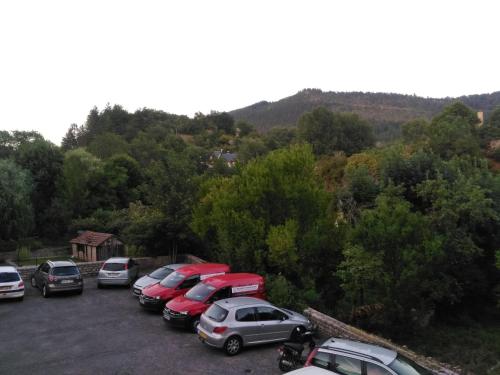 a row of cars parked in a parking lot at Hotel Lou Cantou in Chanac