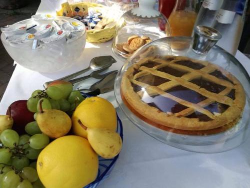 a table with a pie and a bowl of fruit at Relais Villa Poschi in Pugnano