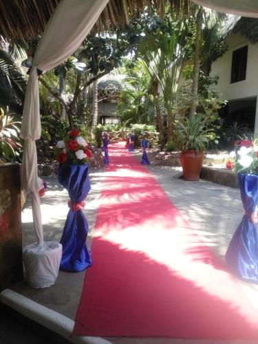 a pink and blue carpeted walkway with people walking down it at Scorpio Villas Resort in Malindi