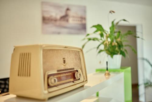 an old radio sitting on a table with a plant at Hotel Zur alten Stadtkellerei Leipzig in Leipzig