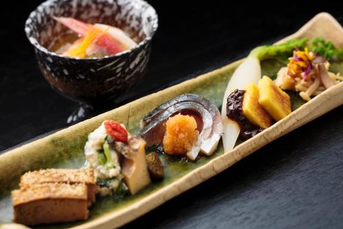 a plate of food on a table with a bowl of food at Hakkei in Maniwa