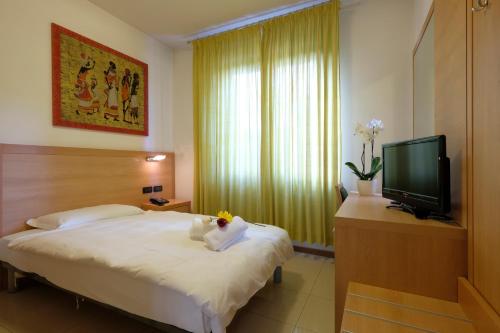 ヴェローナにあるVilla Mimosaのベッドとテレビが備わるホテルルームです。