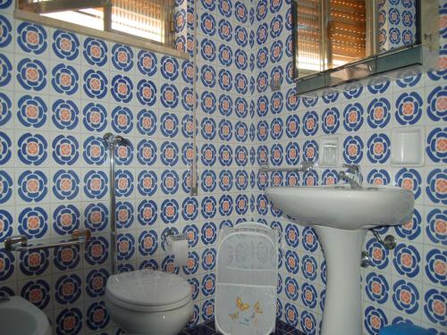 モーディカにあるCasa Fontanaの青と白のタイル張りの壁のバスルーム
