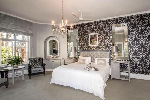 - une chambre avec un grand lit blanc et un lavabo dans l'établissement The Villa Rosa Guest House & Self-catering Apartments, au Cap