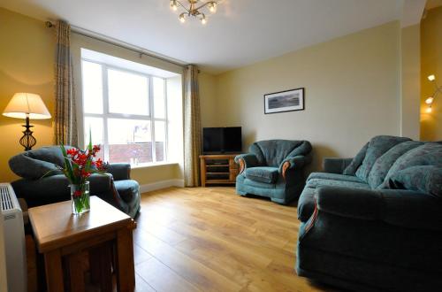 uma sala de estar com dois sofás e uma televisão em Harbour Haven em Dingle