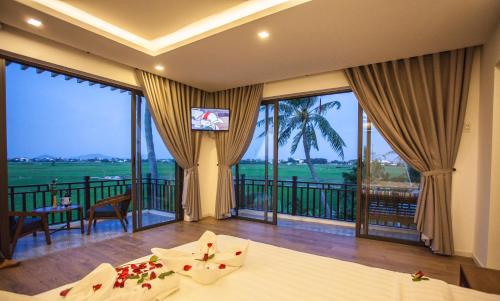 1 dormitorio con balcón con vistas al océano en Hoi An Four Seasons Villa en Hoi An