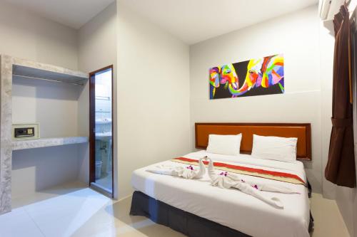 una camera da letto con un letto con lenzuola bianche e una finestra di Freedom Hotel a Patong Beach