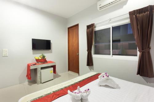 una camera d'albergo con letto e TV di Freedom Hotel a Patong Beach