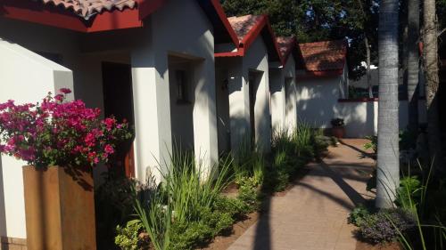 a courtyard of a house with pink flowers at Marlot Guest House in Polokwane