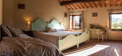 a bedroom with a bed and a table and a chair at Casale Talevi in Cartoceto
