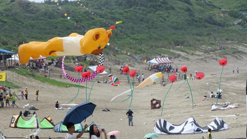 a group of people on a beach flying kites at Emoonten Homestay in Sanzhi