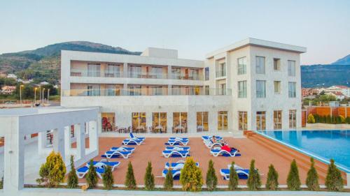 a hotel with a swimming pool and blue lounge chairs at Hotel Franca Tivat in Tivat