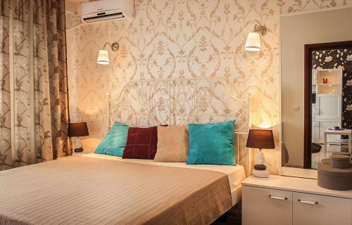 ein Schlafzimmer mit einem großen Bett mit blauen Kissen in der Unterkunft Apartment Bruno Summerland in Mamaia
