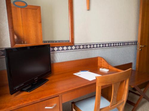 a desk with a television on top of it at Hotel Kroma in Ragusa