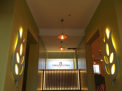 a hallway of a store with lights on the wall at Hotel Vitoria in Santarém