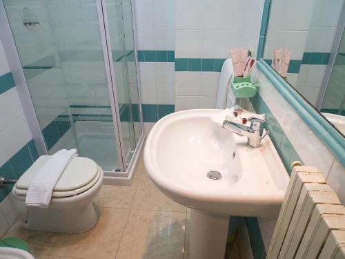 a bathroom with a sink and a toilet and a shower at Hotel Kroma in Ragusa