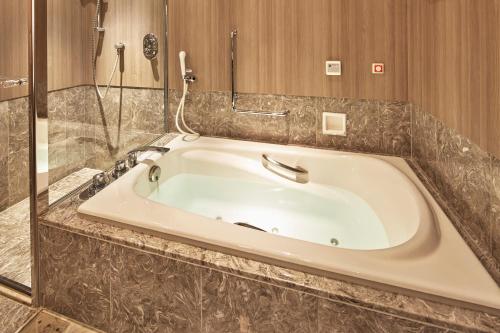 a large bath tub in a bathroom with a shower at The Prince Park Tower Tokyo - Preferred Hotels & Resorts, LVX Collection in Tokyo