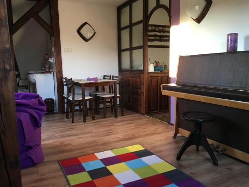 ein Wohnzimmer mit einem Klavier und einem Tisch in der Unterkunft Apartman Adele in Rumburk