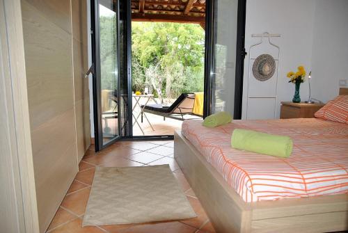 スペルロンガにあるVILLA MIRABELLE Relax e Natura immersi nelle verdi collineのベッドルーム1室(ベッド1台付)が備わります。パティオの景色を望めます。