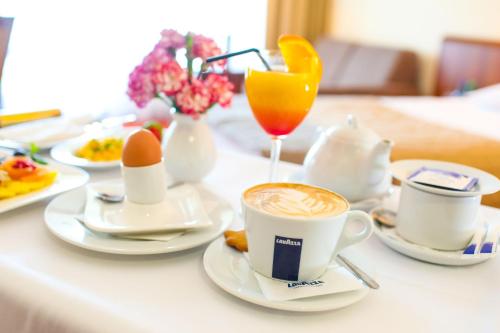 a table with cups of coffee and eggs and a drink at Hotel Belweder in Ustroń